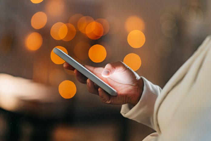 Bokeh, communication and social media, a black woman with phone typing at night with city lights in background. Technology, surfing the internet or browsing online shopping, contact in the evening.