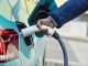 A side view close up shot of an unrecognisable mid adult businessman wearing formal businesswear putting his electric car on charge at a public charging point in Newcastle upon Tyne in the North East of England.