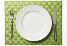 Place setting on green place mat isolated on white background with clipping path.