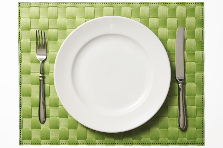 Place setting on green place mat isolated on white background with clipping path.