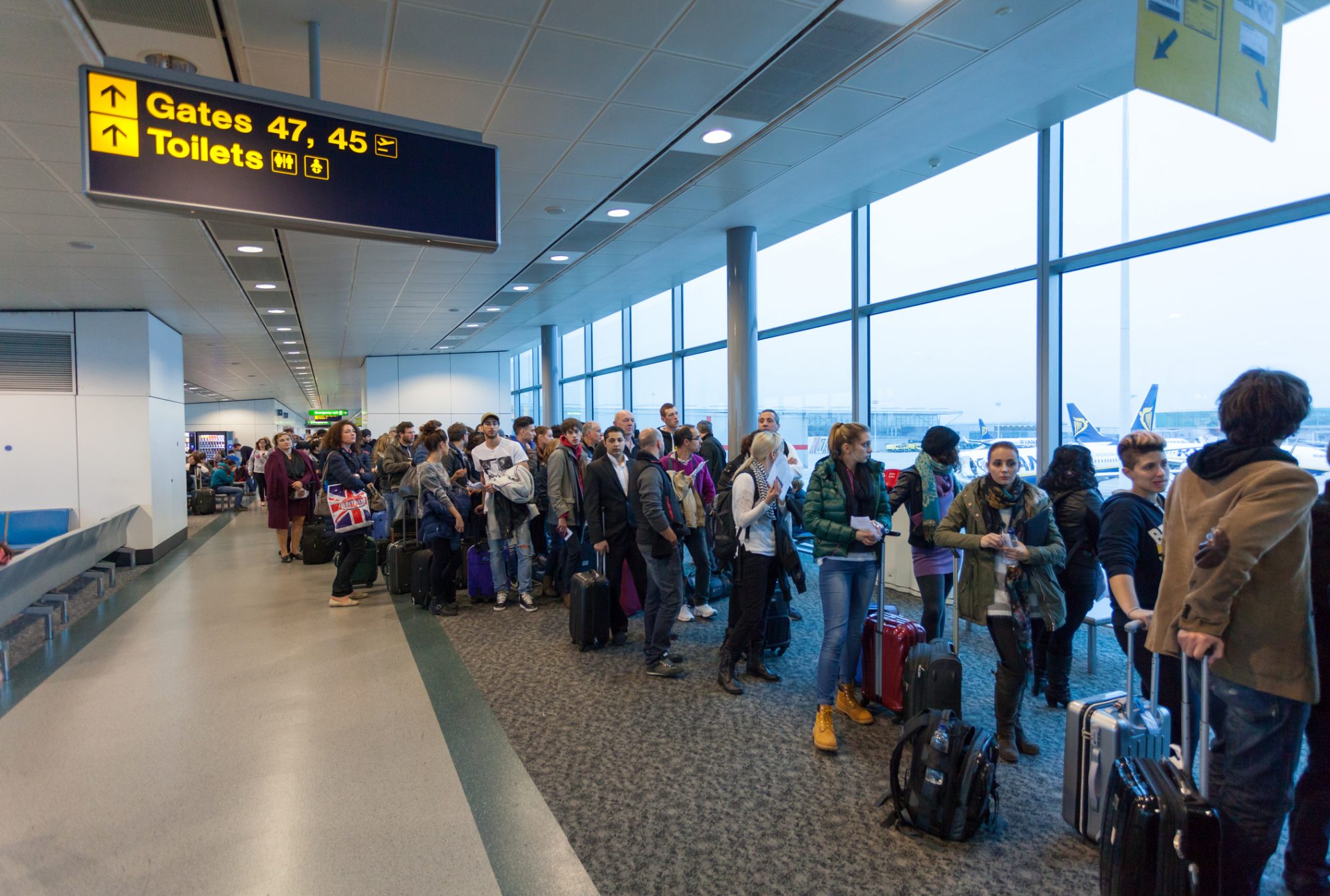 London, United Kingdom - November 2, 2013: Air traveller waiting in queue for boarding at London Stansted Airport.