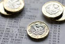 Five UK one pound coins placed on a till receipt.