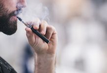 Young male worker smoking electronic cigarette