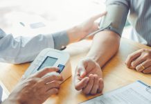 Doctor Measuring arterial blood pressure with man patient on arm Health care in hospital