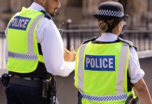 31st August, 2019 - Male and female Asian metropolitan police officers patrol the crowds of tourists outside the Hoses of Parliament in Westminster, London, UK