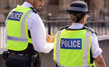 31st August, 2019 - Male and female Asian metropolitan police officers patrol the crowds of tourists outside the Hoses of Parliament in Westminster, London, UK