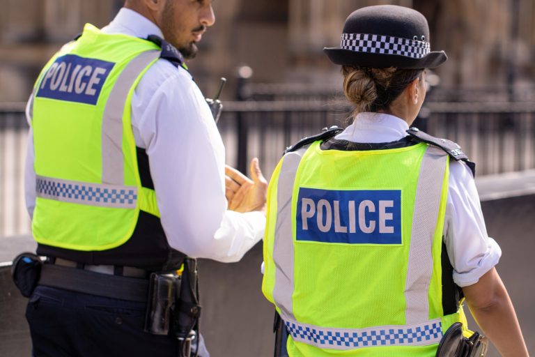 31st August, 2019 - Male and female Asian metropolitan police officers patrol the crowds of tourists outside the Hoses of Parliament in Westminster, London, UK