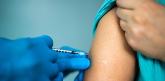 Doctor's hands vaccinating a woman