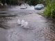 cars driving through flooded road caused by burst water main