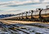 A very long oil train passing through a railyard in Havre, Montana, transporting fossil fuel from the oil fields of Williston, North Dakota. High resolution color photograph with copy space for your message. Horizontal composition.