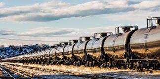 A very long oil train passing through a railyard in Havre, Montana, transporting fossil fuel from the oil fields of Williston, North Dakota. High resolution color photograph with copy space for your message. Horizontal composition.