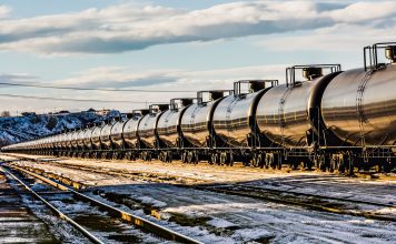 A very long oil train passing through a railyard in Havre, Montana, transporting fossil fuel from the oil fields of Williston, North Dakota. High resolution color photograph with copy space for your message. Horizontal composition.