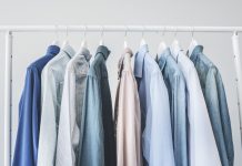 Assorted blue shirts hanging on wooden hangers