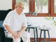 Old Asian senior man feel pain, ache, hurt at knee while standing and sitting at home, osteoarthritis concept