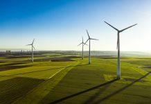 Aerial View of Wind Turbines and Agriculture Field in the Early Morning at Sunrise.