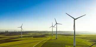 Aerial View of Wind Turbines and Agriculture Field in the Early Morning at Sunrise.