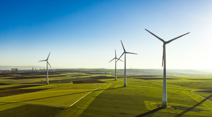 Aerial View of Wind Turbines and Agriculture Field in the Early Morning at Sunrise.