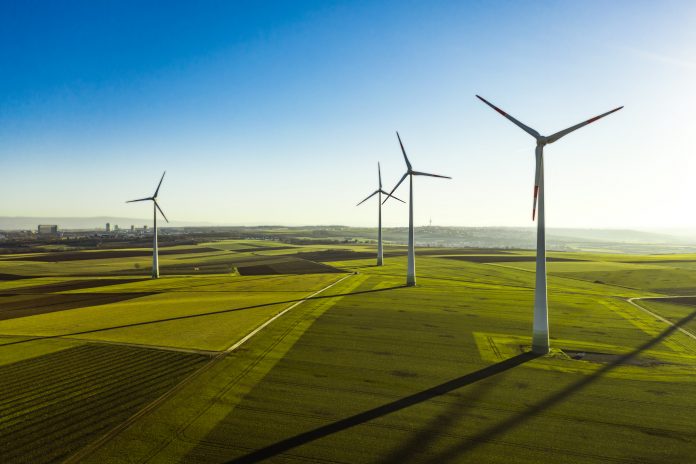 Aerial View of Wind Turbines and Agriculture Field in the Early Morning at Sunrise.