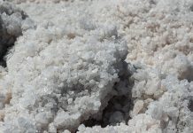 Large stone salt crystals extracted from salt mines in artificial waters at sun