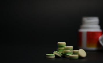 close-up young women holding pills vitamin