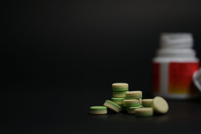 close-up young women holding pills vitamin