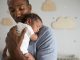 Father Holding Newborn Baby Son In Nursery