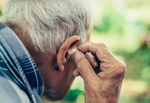 Elderly Man Inserting His Hearing Aid