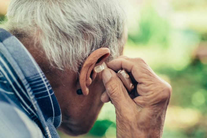 Elderly Man Inserting His Hearing Aid