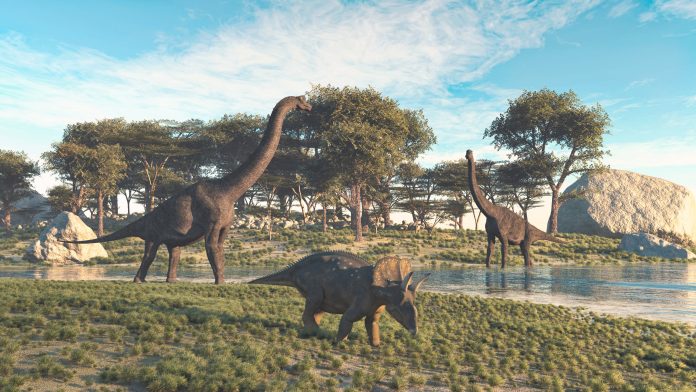 Brachiosaurus and triceratops in the valley at the lake .