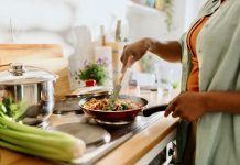 Woman preparing quinoa vegetable mix cooked in a frying pan