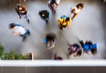 High angle view of large group of students running through the school hallway. Blurred motion.