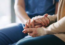 Cropped shot of a senior woman holding hands with a nurse