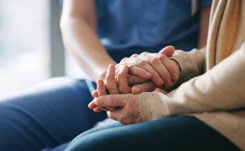 Cropped shot of a senior woman holding hands with a nurse