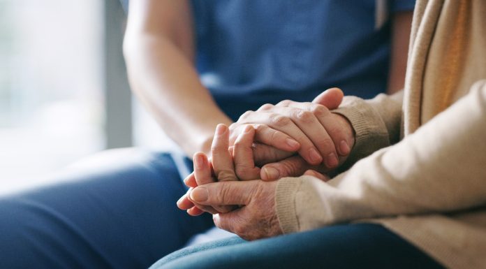 Cropped shot of a senior woman holding hands with a nurse