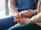 Cropped shot of a senior woman holding hands with a nurse