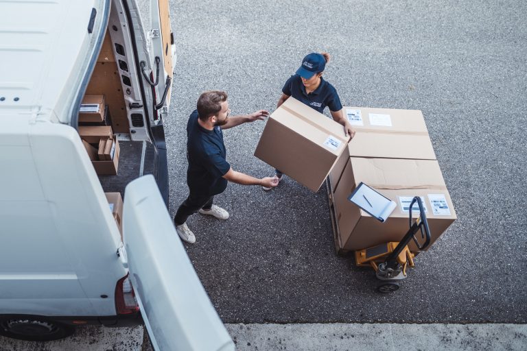 Coworkers rushing to load packages in a delivery van