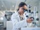 Shot of a young scientist using a microscope while conducting research in a laboratory