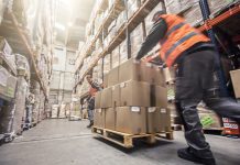 Motion blur of two men moving boxes in a warehouse