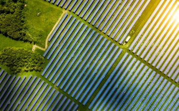 Aerial view over Solar cells energy farm in countryside landscape
