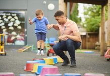 nursery worker with child in playground