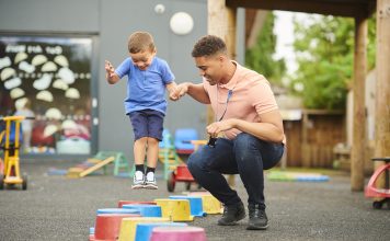 nursery worker with child in playground