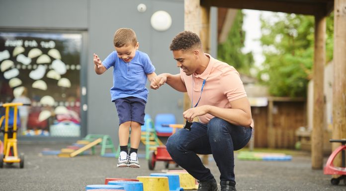 nursery worker with child in playground