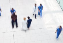 Overhead View Of Medical Staff Walking Through Lobby Of Modern Hospital Building With Motion Blur