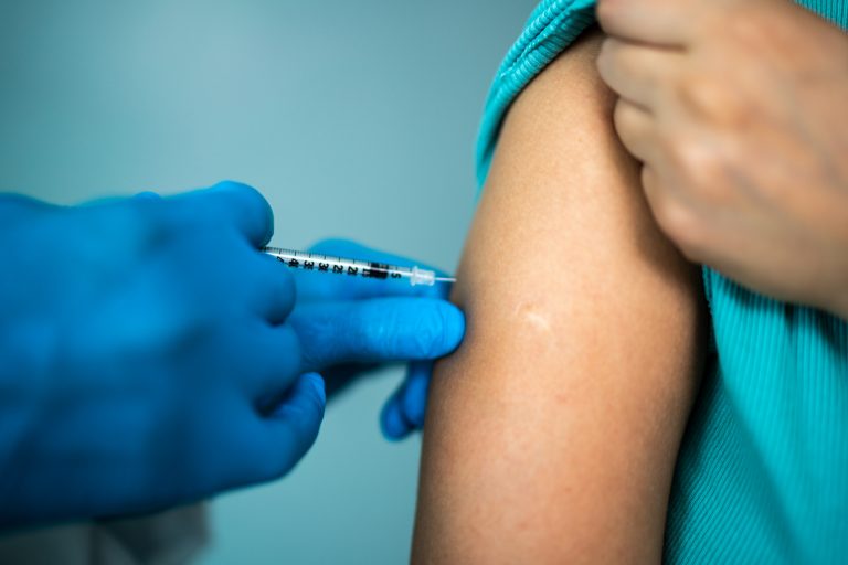 Doctor's hands vaccinating a woman