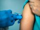 Doctor's hands vaccinating a woman