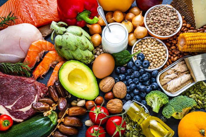 Overhead view of a large group of healthy raw food for flexitarian mediterranean diet. The composition includes salmon, chicken breast, canned tuna, cow steak, fruits, vegetables, nuts, seeds, dairi products, olive oil, eggs and legumes. High resolution 42Mp studio digital capture taken with SONY A7rII and Zeiss Batis 40mm F2.0 CF lens