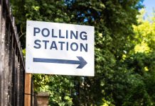 A sign directing voters towards a polling station.