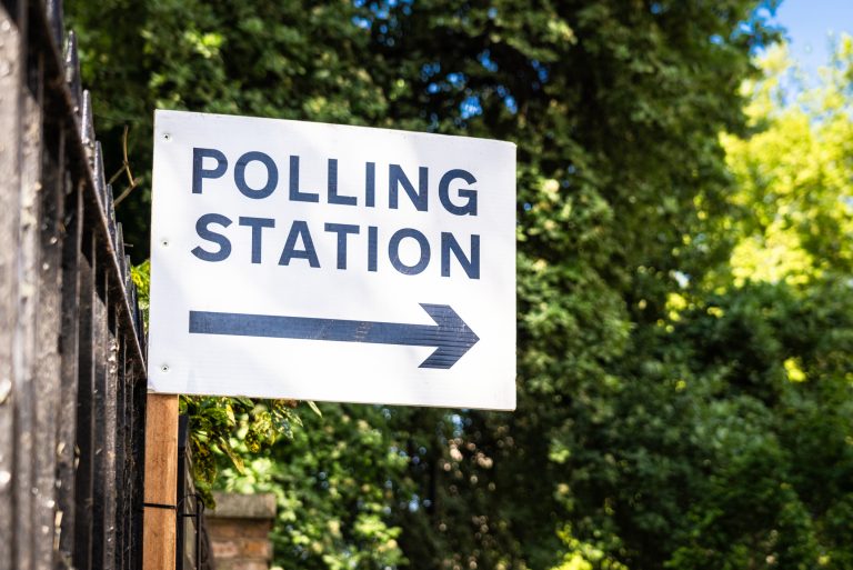 A sign directing voters towards a polling station.