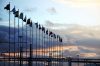 International flags on industrial background at sunset. Global warming and united nations concept.