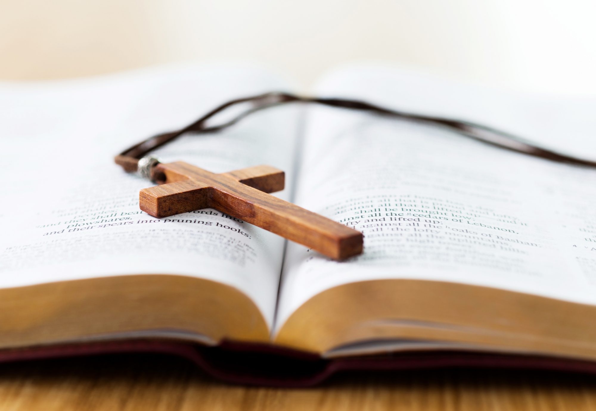 Bible and cross on desk.